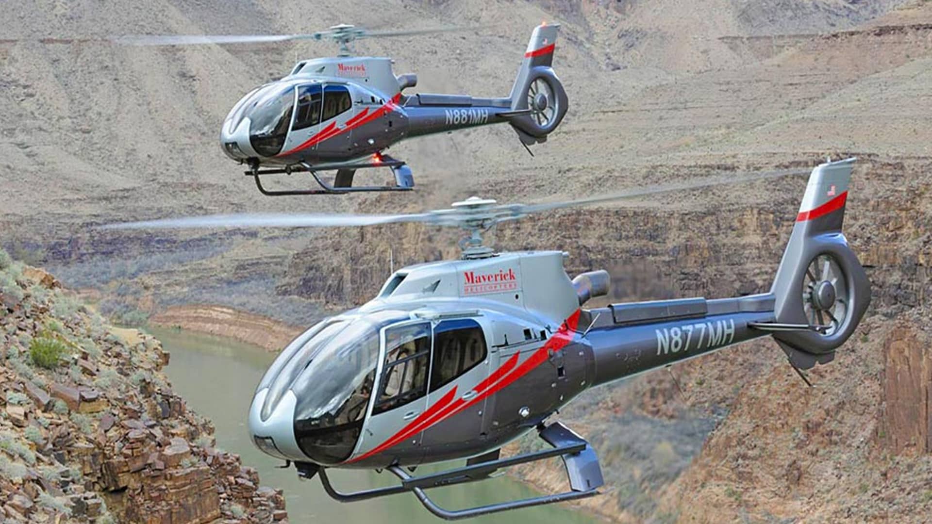 two maverick helicopters flying over canyon